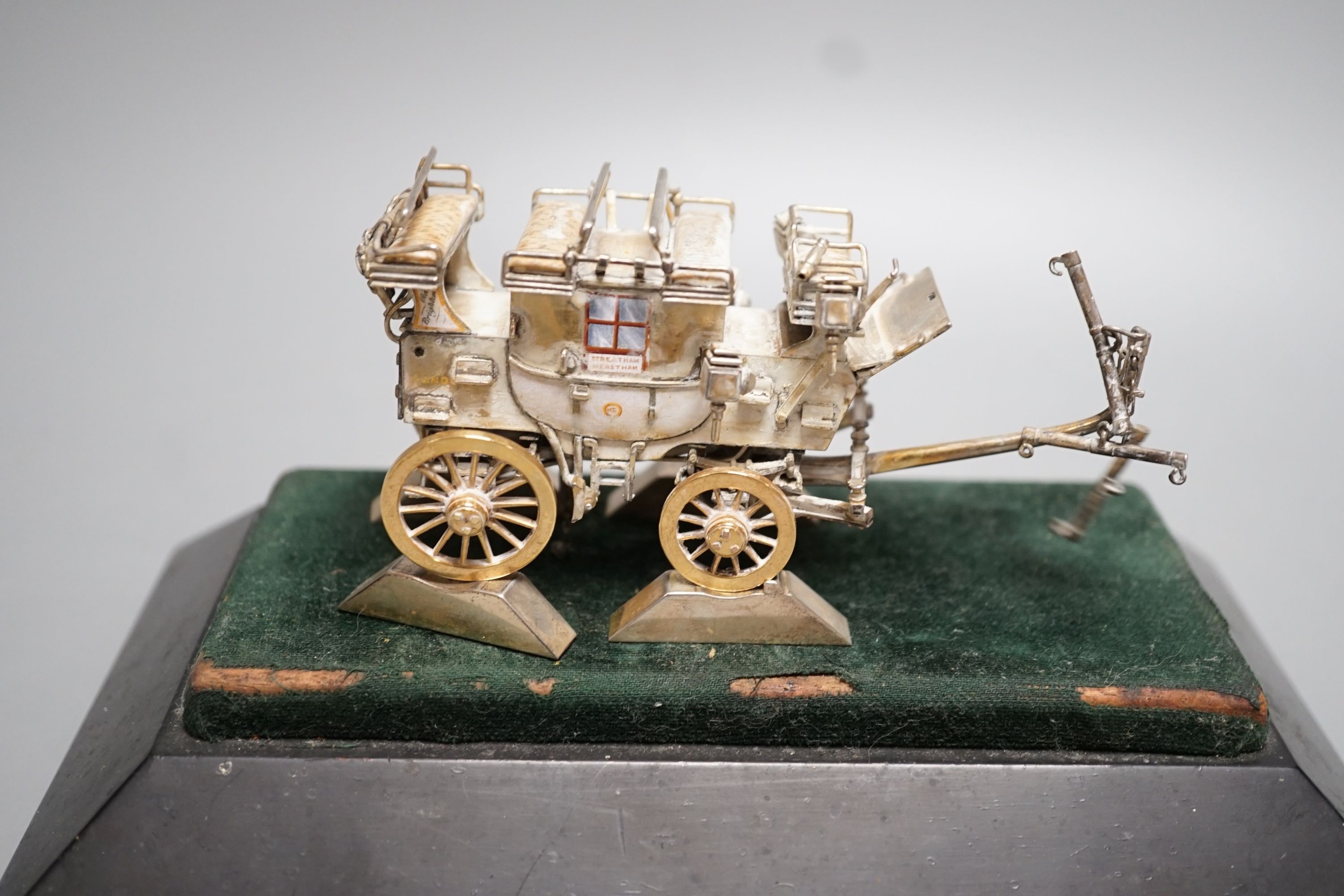 A parcel gilt white metal and enamelled miniature model of 'The Old Times Coach Made To Commemorate Jim Shelby's Record Run To Brighton and Back, 13th July, 1888', on plinth base with engraved inscription, overall 12.8cm